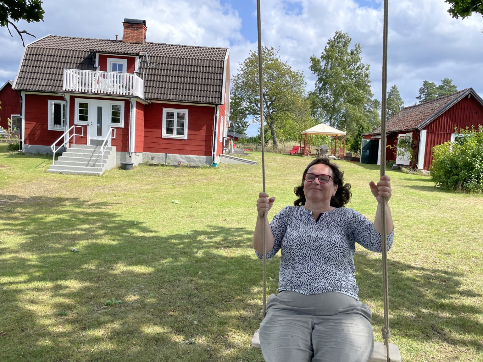 Martina auf der Schaukel vor dem Haus